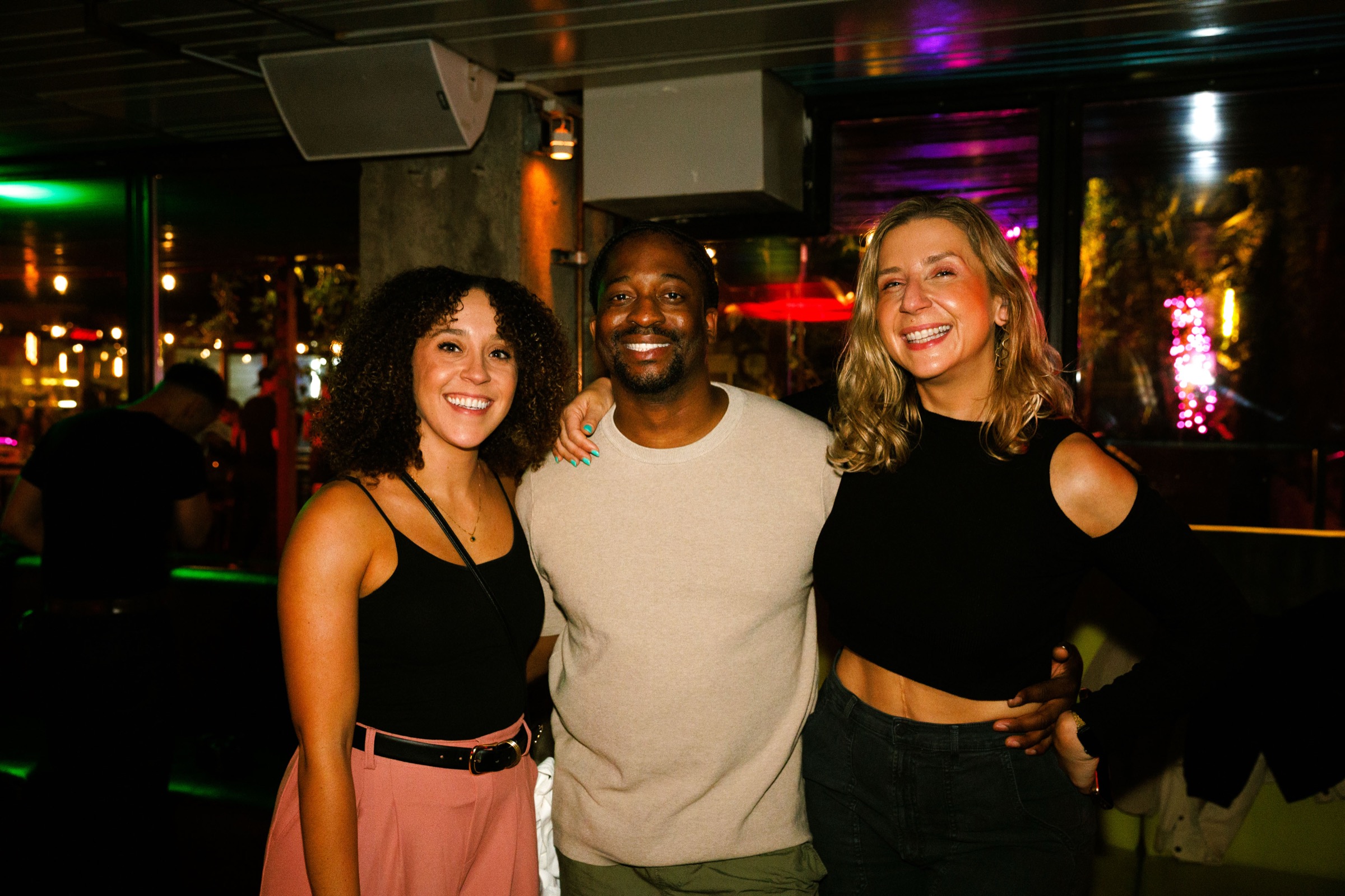 Three people smiling together at a Rhythm of Resilience night
